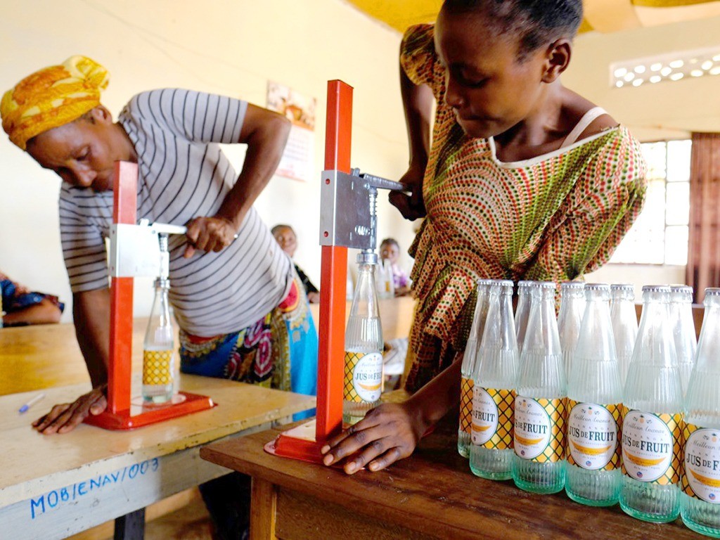 デザインしたパイナップルジュースのラベル、収入向上支援としてジュースを生産するアフリカの人々